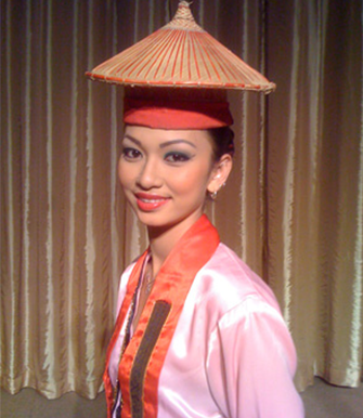 The Tukuo consists of a piece of red cloth over a tall cylindrical hat intricately woven with bamboo strips.